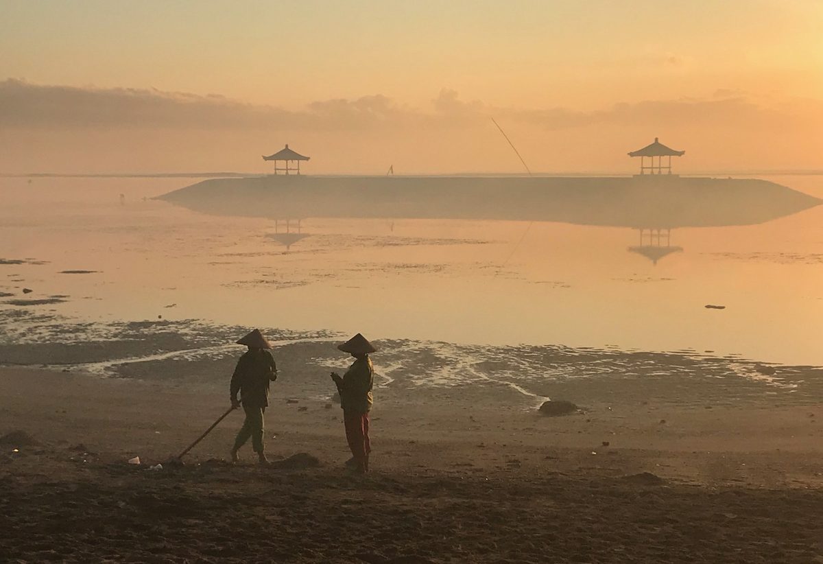 Foto arsip petugas membersihkan Pantai Sanur pada pagi hari, 5 Mei 2018. Ilustrasi lingkungan pesisir, bukan dokumentasi Pekan Iklim 2026. Foto: Mike Dickison / Wikimedia Commons, CC BY-SA 4.0.